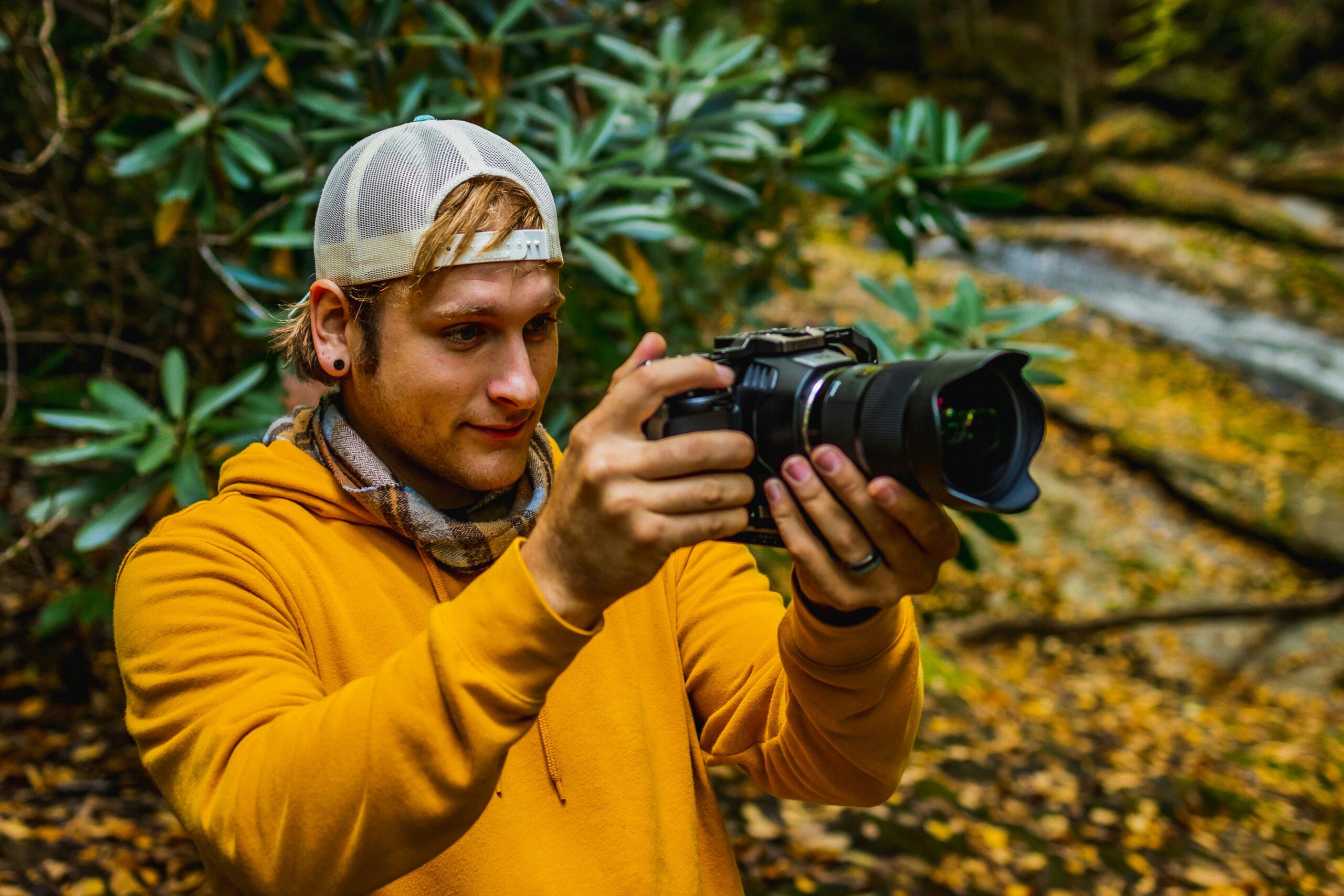 man in yellow jacket holding black dslr camera